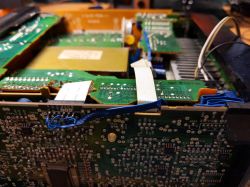 Zbliżenie na wnętrze urządzenia elektronicznego, widoczne płytki drukowane i okablowanie.