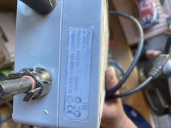 Tabliczka znamionowa zasilacza Photon Power Supply z danymi wejścia i wyjścia elektrycznego.
