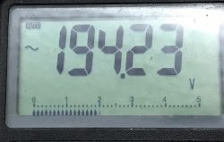 Multimeter display showing a voltage of 194.23 V.