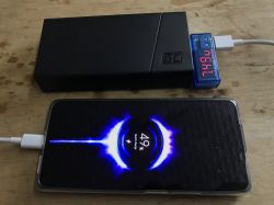 Czarny powerbank GC podłączony do telefonu Xiaomi z wyświetlonym poziomem naładowania 49%.