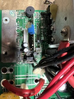 Wnętrze przetwornicy: płytka PCB z przewodami, radiatorem i elementami; widoczne nadpalenie przy złączu.
