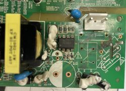 Nahaufnahme einer beschädigten Leiterplatte mit Brandspuren und fehlenden SMD-Bauteilen.