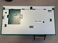 Zbliżenie na wnętrze urządzenia elektronicznego z obudową i widoczną płytą główną.