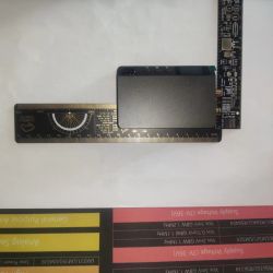DP100 power supply on white background next to measuring ruler and circuit board
