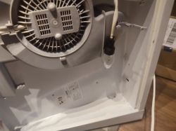 Wnętrze okapu kuchennego z widoczną żarówką i wentylatorem