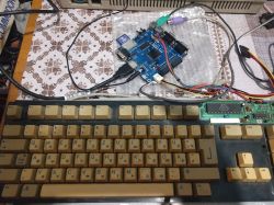 Keyboard with FPGA board and wires on a table.