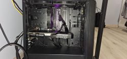 Otwarta obudowa komputera z widocznymi podzespołami, w tym karta graficzna MSI GeForce RTX i podświetlone elementy.