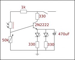 Schemat układu elektronicznego z tranzystorem, fotorezystorem, potencjometrem i diodami LED