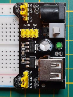 Close-up of a prototype development board with 3.3V and 5V markings and yellow jumpers.
