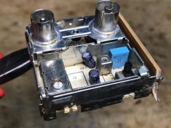 Głowica elektroniczna z tunera satelitarnego z widocznymi kondensatorami i metalowymi złączami.