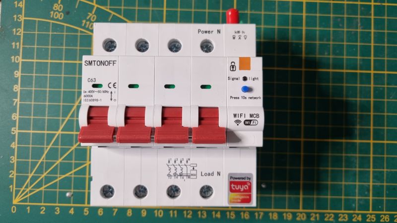 Tuya DIN 4P 1-63A Device with WiFi Tuya DIN 4P 1-63A device with WiFi features on a green measurement mat.