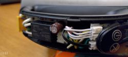 Interior of an electric kettle with visible electronic components, including a capacitor and wires.