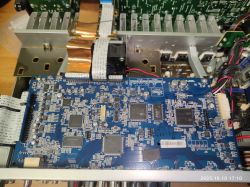 Płyta główna urządzenia elektronicznego z widocznymi układami scalonymi i taśmami połączeniowymi