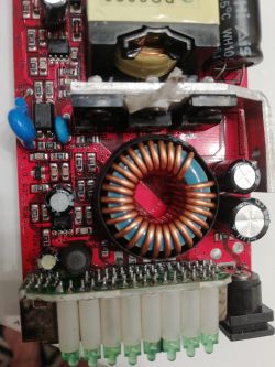 Płyta główna z widocznymi elementami elektronicznymi, w tym spalonymi rezystorami.