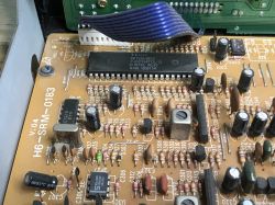 Zbliżenie na płytę PCB starego tunera satelitarnego z widocznymi elementami elektronicznymi.