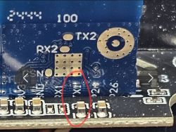 Close-up of a PCB with TX2, RX2 markings and red oval highlighting a trace