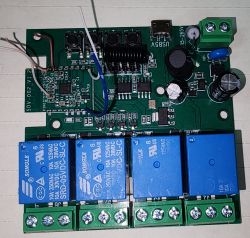 Circuit board with blue relays and various electronic components.