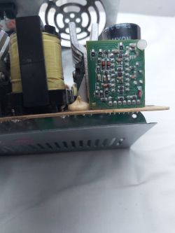Zbliżenie na układ elektroniczny z widoczną płytką drukowaną oraz kondensatorem.