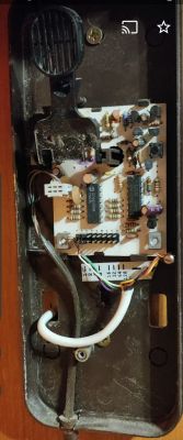 Wnętrze starego domofonu z widoczną płytką elektroniczną i przewodami.