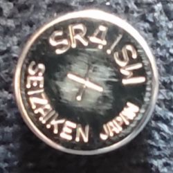 Zdjęcie baterii guzikowej z oznaczeniami 