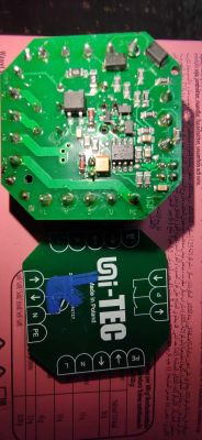 Dwie zielone płytki drukowane leżące na różowym tle, z elementami elektronicznymi i oznaczeniami z nazwą uni-TEC.