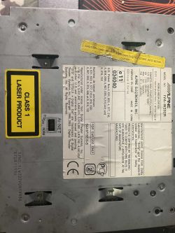 Tabliczka znamionowa na spodzie radia Alpine IVA-W202R z ostrzeżeniami i danymi technicznymi.