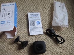 IP Smart Camera Kit Contents IP camera set: camera, USB cable, mount, manual, and box on carpet.