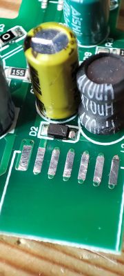 Close-up of a circuit board with visible capacitors and a diode.