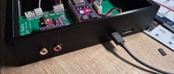 Back of radio casing with ports and PCB with connected cables.