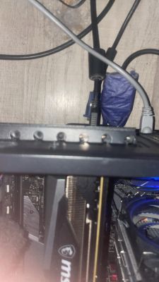 Zbliżenie na tył komputera z podłączonymi różnymi kablami, w tym HDMI.