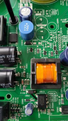 Zbliżenie na płytkę PCB z elementami zasilacza, cewką i kondensatorami