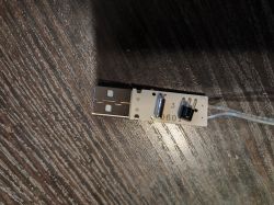 Adapter USB z modułem sterującym na drewnianym stole.