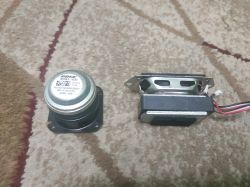 Two small speakers: one round Bose speaker and one rectangular speaker with wires.