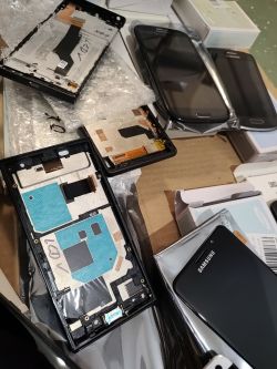 Wyświetlacze Samsung i części do naprawy ekranów rozłożone na kartonie