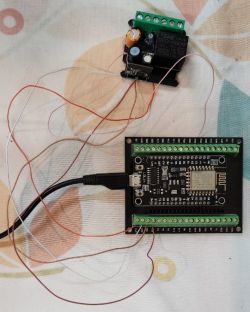 Electronic board with long wires connected, lying on a colorful background.