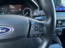Interior of a Ford car with a steering wheel, digital display, and control buttons.
