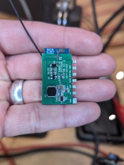 Tuya WB3S-IPEX Module Disassembled Electronic module in a person's hand showing the Tuya WB3S-IPEX chip with an antenna.