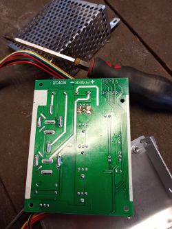 Zbliżenie na płytkę drukowaną z oznaczeniami POWER i MOTOR oraz śrubokrętem obok.