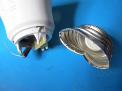 Close-up of a damaged LED bulb with a detached metal screw base.