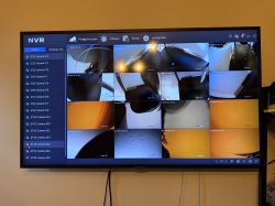 Ekran monitora wyświetlający podgląd z wielu kamer monitoringu w systemie NVR, widocznych jest 16 okien z obrazem z kamer.