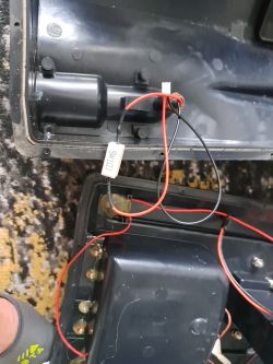 Czarny plastikowy korpus z przewodami czerwonymi i czarnymi oraz złączami elektrycznymi