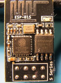 Close-up of an ESP-01S module featuring an ESP8266EX chip and replaced 8MB Winbond memory chip.