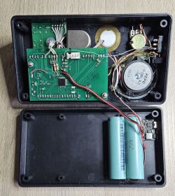 Wnętrze ręcznie wykonanego metronomu elektronicznego z widocznymi płytkami PCB, okablowaniem, głośnikiem, piezo oraz dwoma ogniwami 18650.