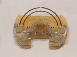 Przecięty element wnętrza elektronicznego z metalowymi końcówkami.