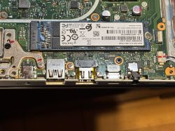 Zbliżenie na płytę główną laptopa ASUS R564U z widocznym dyskiem SSD SanDisk