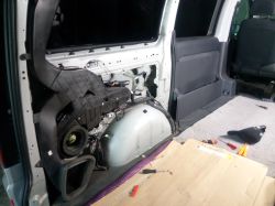 Zdjęcie wnętrza bocznej części Mercedesa Vito W639 z demontowaną plastikową tapicerką, widocznym nadkolem i brakiem przewodów do głośnika.