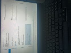 Ekran BIOS/UEFI z opcjami AMD Platform Security Processor i Secure Boot obok klawiatury laptopa