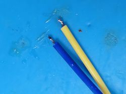 Soldered Wires on Blue Background Two soldered wires on a blue background.