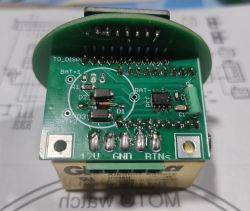 Zbliżenie na zieloną płytkę PCB z elementami SMD i opisami BAT, GND, 12V
