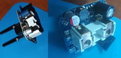 Two electronic circuit boards with new capacitors soldered on, lying on a white surface.